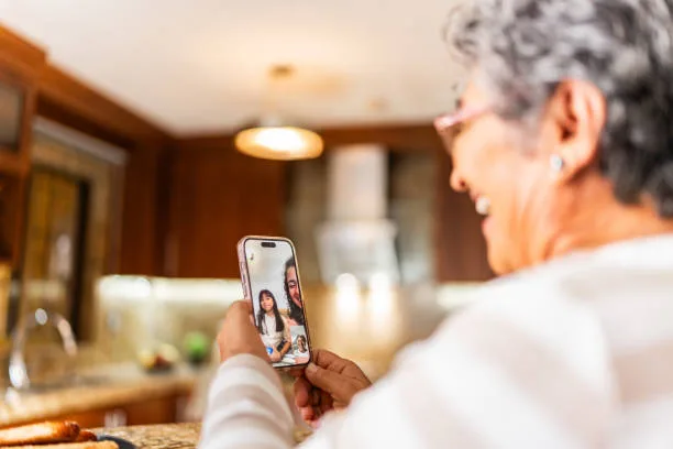 Senior woman talking to family on video call at home