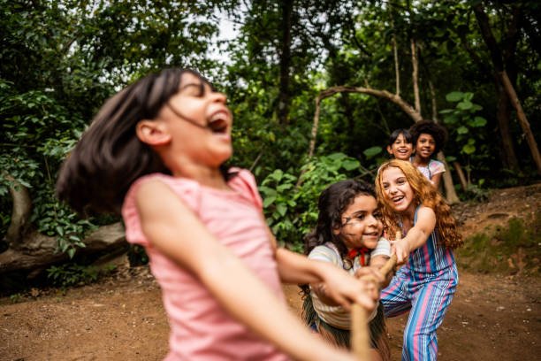 Children playing tug of war during a field trip in a summer camp